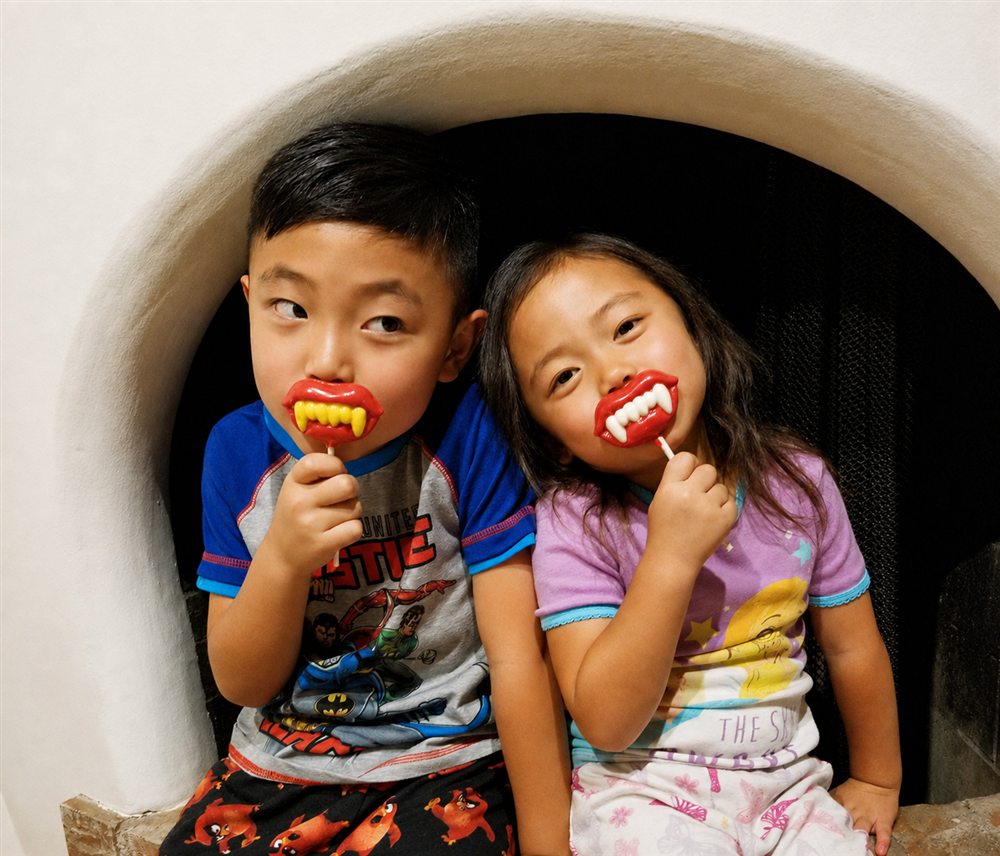Kids having fun with vampire teeth lollipops — children's dentistry at Noa Dental